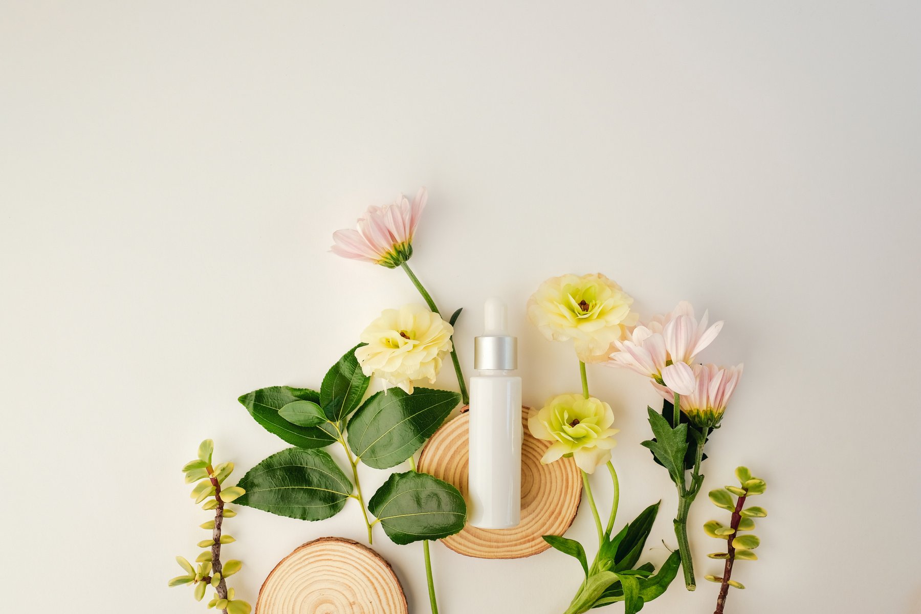 Cosmetic Product with Flowers on White Background